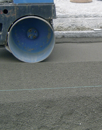 Processing / compacting of the drain concrete base course by a static roller.